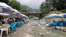 Dozens line stream in southern China as they play mahjong in searing sun