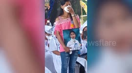 Grieving mother carries dead daughter's portrait to high school graduation