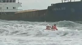 Coast guards battle to pull stranded ship crew's rescue boat against choppy waters in the Philippines