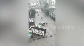 Hero neighbours save driver being washed away by flood in the Philippines