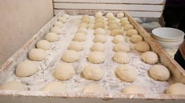 Palestinian vendors prepare traditional bread known as