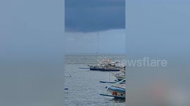 Panicked tourists watch as waterspout form near port in the Philippines
