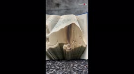 Artist brilliantly folds book pages to recreate the Red Bull logo