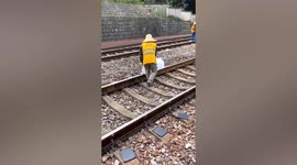 Workers use big ice cubes to cool overheated train track in China