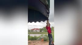 Villagers battle to hold up tent during storm in Thailand