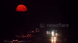 Full 'Buck' Supermoon seen rising over the M2 motorway in Kent, UK