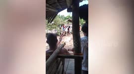 Residents cross bamboo bridge over surging river in the Philippines