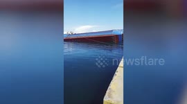 Cargo vessel overturns while loading delivery trucks at port in the Philippines