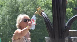 People fill up water bottles in London's Green Park as temperatures rise during UK heatwave