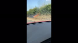 Fire by the road following a wheat field catching fire in Norfolk during UK heatwave