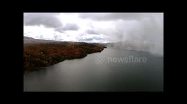 Drone captures autumn snowstorm crossing Canadian lake