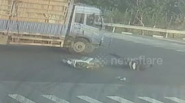 Motorcyclist slides across road after crash... misses lorry by inches