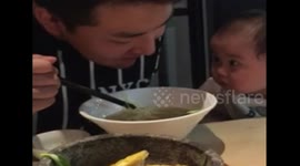 Cute baby stares intensely at dad while he eats