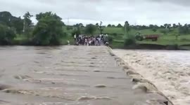 People perilously cross culvert with water on it in central India