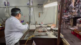 Watch repairman works on market stall in Phnom Penh, Cambodi