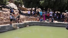 Israeli settlers gather around a water spring in the village of Ein Qinya, west of Ramallah in the West Bank, under the protection of the Israeli army