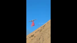 Firefighters battle to contain wildfire burning close to highway in California