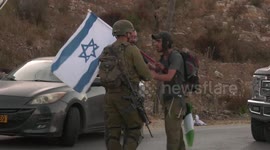 Palestinian and Israeli activists argue with troops and setters at protest against right-wing settlers' new settlements