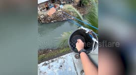 Shopkeeper uses huge pulley from hillside over river to serve customers