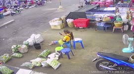 Ceiling fan falls, hitting market stall vendor playing with her phone