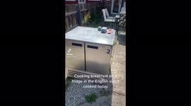 Man cooking breakfast in the uk heatwave just using the sun