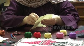 Palestinian Sahar Herzallah sews traditional products with her daughter on the Palestinian Traditional Dress Day at their home