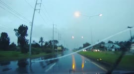 Pickup truck spins out of control into electricity post on wet road in Thailand
