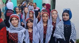 Palestinians take part in an event on the Palestinian Traditional Dress Day at Al Qarara Cultural Museum