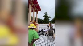 Buddhist monk slides on slippery floor during religious ceremony in Thailand