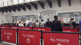 People waiting in line queueing at ticket sales King's cross station London UK