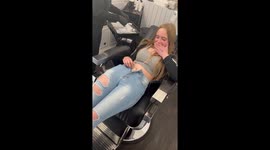'Girl relaxing on couch while getting her first belly piercing
'