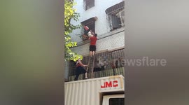Two men save toddler hanging out of window in China
