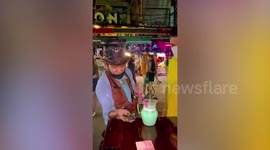 Thai street magician amuses passersby with impressive magic tricks