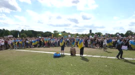 Ukrainians sing the national anthem at a rally in Berlin, Germany