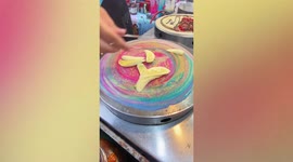 Watch these delicious rainbow-colored pancakes prepared at street food stall in Thailand