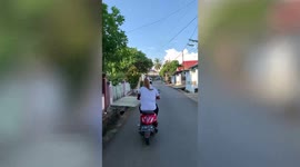 Cat rides on motorcycle rider's shoulder's in Indonesia