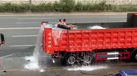 Men play in truck filled with water due to hot weather in China