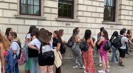 Tourists form long queue to take photos next to a red telephone box in Westminster