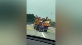 Driver clings onto back of truck as it crashes down road in southern China