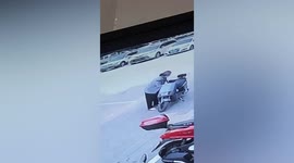 Elderly Chinese woman steals groceries hanging on scooter outside shop