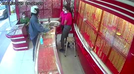 Bizarre moment shop assistants stay calm while gun-wielding robber steals gold jewellery