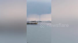 Large waterspout forms next to fishing boats in the Philippines