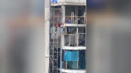 Carefree worker balances on flimsy PLANK without a harness 75ft above the ground