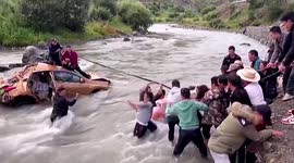 Police officers and residents rescue couple trapped in car that fell into river in China
