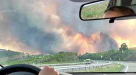 Motorists drive along countryside shrouded in smoke as fires erupt in Spain's Galicia