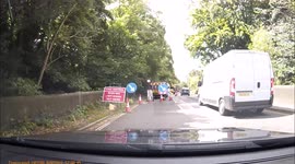 White van overtakes traffic and goes through red traffic lights in Baslow in the peak district
