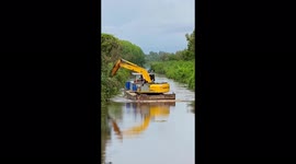 The excavator driver uses a bucket to move the ferry at high speed on the rive