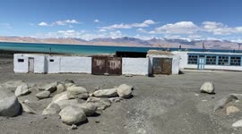 Deep blue water of Karakul lake, situated 4000 meters above sea level and surrounded by snowy mountains, in the famous Pamir Highway
