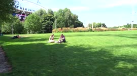 Londoners relax in the sun next to ArcelorMittal Orbit in Queen Elizabeth Olympic Park