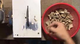 Carpenter uses his bare hands to cut small logs with a chainsaw blade